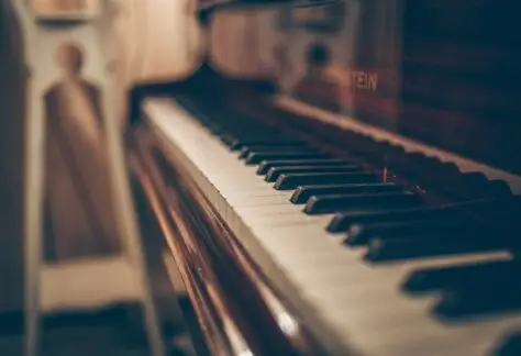 a close up of a piano with a person in the background