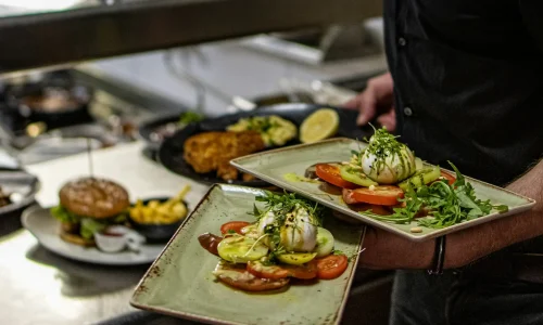 a man holding two trays of food